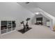 Spacious bonus room with a vaulted ceiling, carpeted floors, and home gym equipment at 4589 Freedom Dr, Burlington, NC 27215
