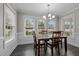 Dining room filled with natural light featuring a modern chandelier, four windows, and seating for six at 4589 Freedom Dr, Burlington, NC 27215