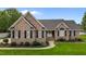 Charming brick home featuring a well-manicured lawn, black shutters, and a classic entryway at 4589 Freedom Dr, Burlington, NC 27215