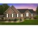 Charming brick home with manicured lawn, black shutters, and a classic entryway under a twilight sky at 4589 Freedom Dr, Burlington, NC 27215