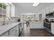Open kitchen with white cabinets, stainless appliances, a window over the sink, and dark wood floors at 4589 Freedom Dr, Burlington, NC 27215