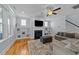 Open living room featuring a fireplace with built-in shelves and a comfortable gray sectional sofa at 508 Vervain Way, Holly Springs, NC 27540