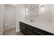 Modern bathroom with sleek black cabinets, neutral countertops, and tile flooring at 5212 Badham Pl, Raleigh, NC 27609