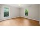 Well-lit bedroom with hardwood flooring and large windows offering backyard views at 5212 Badham Pl, Raleigh, NC 27609