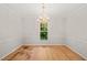 A dining room with hardwood floors, a chandelier, neutral paint, and a view of a front yard at 5212 Badham Pl, Raleigh, NC 27609