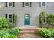Charming home with a green front door, windows with black shutters, and green landscaping at 5212 Badham Pl, Raleigh, NC 27609