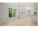 Kitchen and dining area featuring white cabinets, stainless appliances, tile floor, and a view of the front yard at 5212 Badham Pl, Raleigh, NC 27609