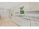 Bright kitchen features white cabinetry, stainless steel appliances, tile backsplash, and window view at 5212 Badham Pl, Raleigh, NC 27609