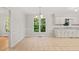 Kitchen and dining space with stainless steel appliances, white cabinets, tile floors, and a view of the front yard at 5212 Badham Pl, Raleigh, NC 27609