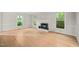 Bright living room features hardwood floors, fireplace, and three windows letting in natural light at 5212 Badham Pl, Raleigh, NC 27609