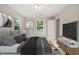 Inviting bedroom featuring a ceiling fan, a mounted TV, and two big windows at 5212 Badham Pl, Raleigh, NC 27609
