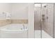 Bright bathroom featuring a soaking tub and separate shower with tiled walls and glass door at 525 Durants Neck Ln, Morrisville, NC 27560