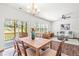 Well-lit dining room with wood table, chandelier, hardwood floors, and access to the back patio at 525 Durants Neck Ln, Morrisville, NC 27560