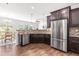 Modern kitchen with stainless steel appliances, granite countertops, and dark wood cabinets at 525 Durants Neck Ln, Morrisville, NC 27560