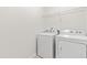 Bright laundry area with side-by-side washer and dryer and wire rack shelving above at 525 Durants Neck Ln, Morrisville, NC 27560