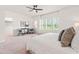 Bright main bedroom boasts a ceiling fan, a sitting area, and large windows providing ample natural light at 525 Durants Neck Ln, Morrisville, NC 27560