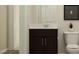 Half bath showcases dark vanity with modern fixtures, bright lighting, and a toilet at 548 Morning Light Dr, Angier, NC 27501