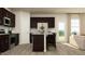 Open kitchen features dark cabinets, stainless steel appliances, and a granite-topped island at 548 Morning Light Dr, Angier, NC 27501