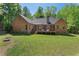 Brick home boasts a lush backyard with a wooden deck perfect for outdoor relaxation at 5524 Jomali Dr, Durham, NC 27705