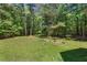 Lush backyard features mature trees and a serene wooded view at 5524 Jomali Dr, Durham, NC 27705