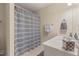 Clean bathroom with striped shower curtain, white vanity, and neutral-toned walls at 5524 Jomali Dr, Durham, NC 27705