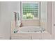 A large tub with jets and a decorative window for natural light at 5524 Jomali Dr, Durham, NC 27705