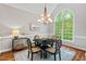 Elegant dining room featuring a decorative light fixture, large window, and hardwood floors at 5524 Jomali Dr, Durham, NC 27705