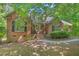 Picturesque brick home with mature trees, arched window, and a cozy front porch at 5524 Jomali Dr, Durham, NC 27705
