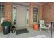 Welcoming front porch area featuring a neutral door, cozy seating, and brick accents at 5524 Jomali Dr, Durham, NC 27705