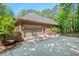 Brick garage with a large door and driveway surrounded by lush green trees at 5524 Jomali Dr, Durham, NC 27705
