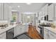 Bright kitchen featuring white cabinetry, quartz countertops, stainless steel appliances, and hardwood floors at 5524 Jomali Dr, Durham, NC 27705