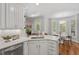Stylish kitchen featuring white cabinetry, quartz countertops, and access to outdoor living space at 5524 Jomali Dr, Durham, NC 27705
