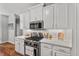 Charming kitchen with white cabinets, stainless steel appliances, and hardwood floors at 5524 Jomali Dr, Durham, NC 27705
