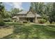 Expansive backyard featuring a brick home, a covered patio, a wooden arbor, and lush green lawn at 5901 Charleycote Dr, Raleigh, NC 27614