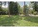 A spacious backyard featuring a stone garden bed and a mature tree line providing shade and privacy at 5901 Charleycote Dr, Raleigh, NC 27614