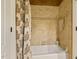 Clean bathroom with tiled walls, tub, and shower curtain with a decorative leaf pattern at 5901 Charleycote Dr, Raleigh, NC 27614