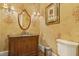 Charming powder room with decorative wallpaper, elegant lighting, and a traditional vanity at 5901 Charleycote Dr, Raleigh, NC 27614