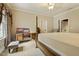 Bright bedroom with a four-poster bed, classic desk, and window seat, perfect for relaxation at 5901 Charleycote Dr, Raleigh, NC 27614
