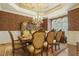 Elegant dining room featuring a crystal chandelier, decorative wallpaper, and seating for six at 5901 Charleycote Dr, Raleigh, NC 27614