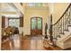 Grand foyer with ornate staircase, hardwood floors, and elegant double doors with decorative glass inserts at 5901 Charleycote Dr, Raleigh, NC 27614