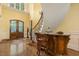 Elegant foyer with a custom bar and stately staircase featuring unique architectural details and wood accents at 5901 Charleycote Dr, Raleigh, NC 27614