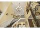 High ceiling with chandelier over curved staircase and second-story landing that accentuates the foyer's grand architecture at 5901 Charleycote Dr, Raleigh, NC 27614