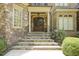 Elegant stone staircase leading to a beautiful entryway with ornate wooden doors and detailed ironwork at 5901 Charleycote Dr, Raleigh, NC 27614