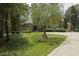 Charming stone house with mature tree, lush green lawn, and large circular driveway at 5901 Charleycote Dr, Raleigh, NC 27614
