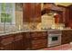 Close-up of kitchen featuring stainless steel Wolf range with custom hood and granite countertops at 5901 Charleycote Dr, Raleigh, NC 27614
