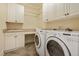 Well-equipped laundry room with sink, folding counter, and ample cabinetry for storage at 5901 Charleycote Dr, Raleigh, NC 27614
