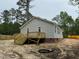 Backyard view of a home featuring a wooden deck and light gray siding, set on a natural landscape at 604 Natchez Trace, Fuquay Varina, NC 27526