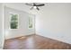 Sunny bedroom with hardwood floors, natural light, and ceiling fan for comfort, featuring two large windows at 604 Natchez Trace, Fuquay Varina, NC 27526