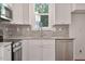 Close up of the kitchen with white cabinets, granite countertops, a window and modern stainless steel appliances at 604 Natchez Trace, Fuquay Varina, NC 27526