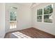 Well-lit room with wood floors, a glass door leading to the outside, and large windows at 604 Natchez Trace, Fuquay Varina, NC 27526